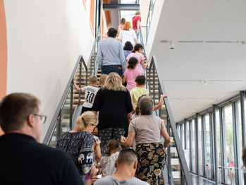 Eine Gruppe Menschen laufen über eine Treppe in den 1. Stock des Museums