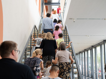 Eine Gruppe Menschen laufen über eine Treppe in den 1. Stock des Museums