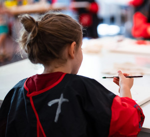 Kinder sitzen an einem Tisch und malen